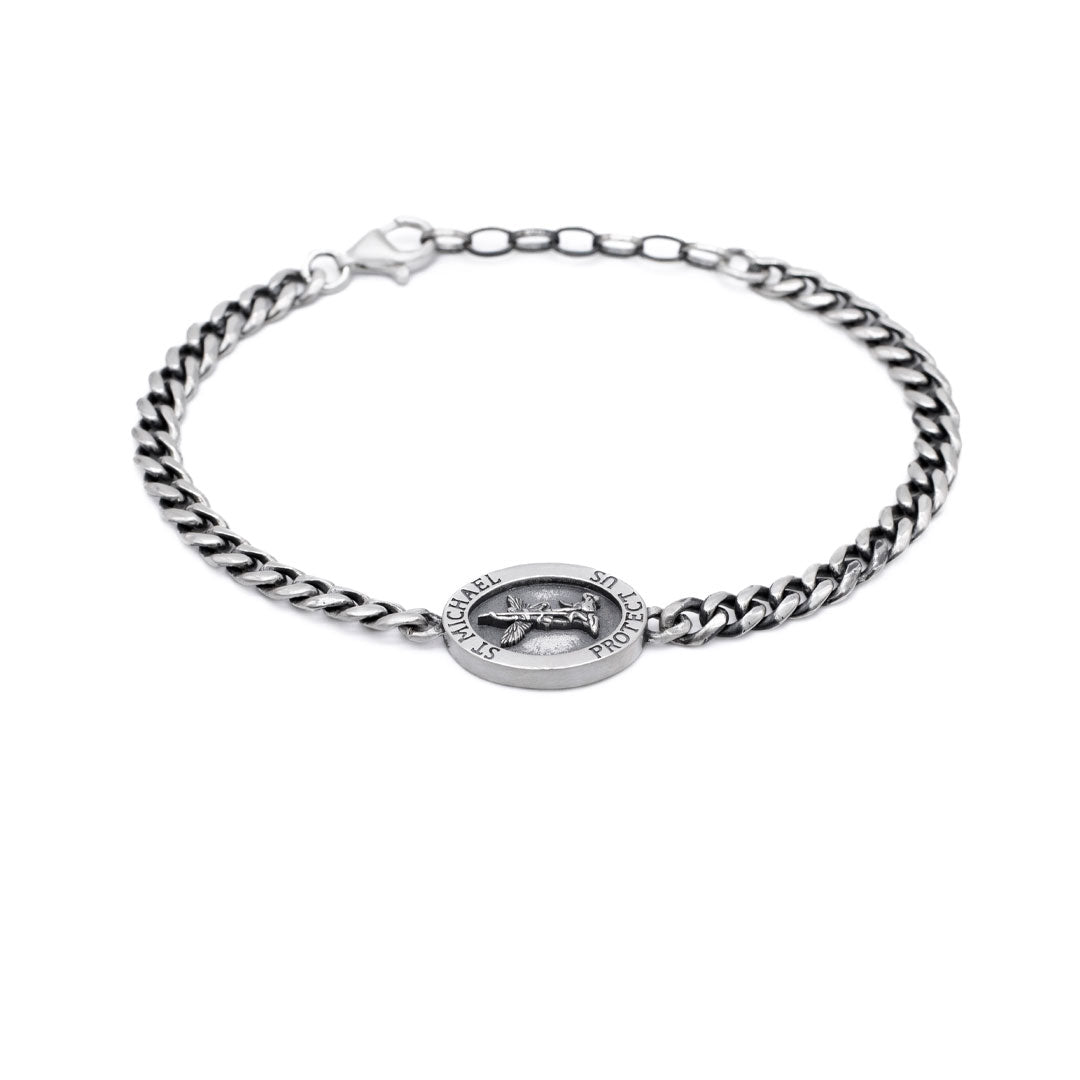 Silver chain bracelet with a round pendant on a white background