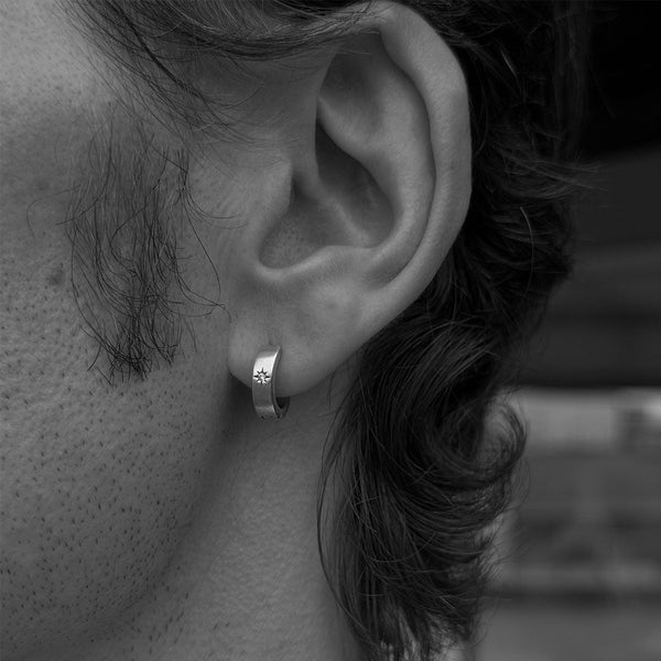 Close-up of an ear with a small hoop earring, black and white photo
