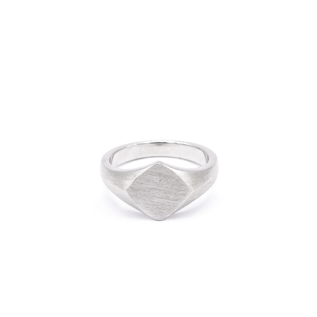 Silver ring with a Rhombus shaped face and heavy brushed finish on a white background