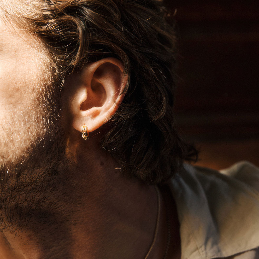 Close-up of a person's ear with an earring, blurred background